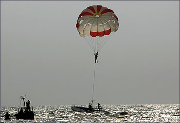 A tourist paraglides on Baga beach in the western Indian state of Goa.