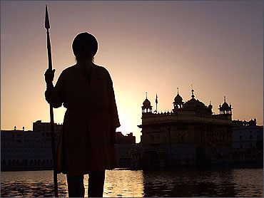 A Sikh temple worker stands guard inside the Golden Temple complex in Amritsar.