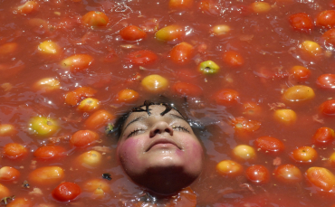 A child rests inside tomato pulp in Hyderabad.