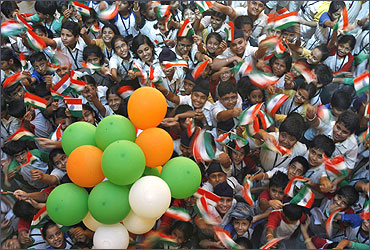 Students wave Indian national flags.
