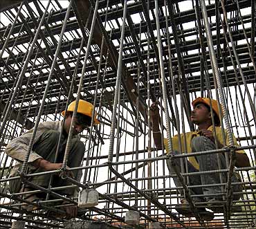 Labourers work at a flyover construction site in Mumbai.