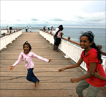 Two girls play on a boardwalk at the sea front in Colombo.