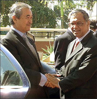 Former Malaysian Prime Minister Abdullah Ahmad Badawi (L) shakes hands with N R Narayana Murthy.
