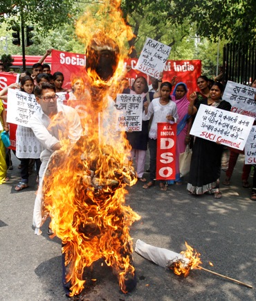 A Socialist Unity Centre of India activist burns an effigy of inflation in New Delhi.