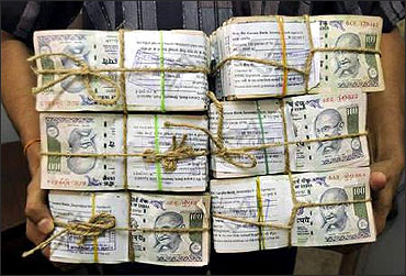 An employee carries bundles of currency notes inside a bank in Agartala.