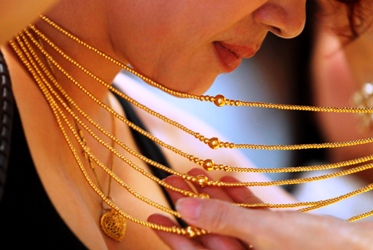 Customer tries on a gold necklace at a gold shop in Hanoi.