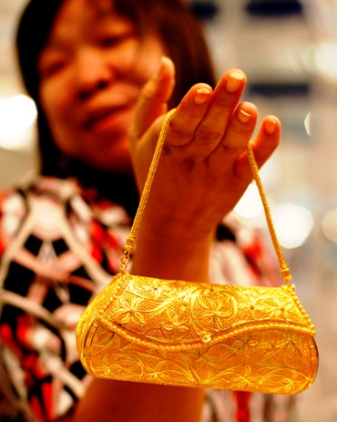 A woman shows a purse made of gold at the Jakarta International Jewellery Fair.
