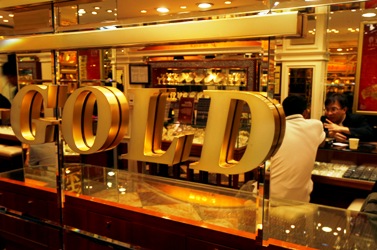 A sales representative talks to a customer at a jewellery store which sells gold in Hong Kong.