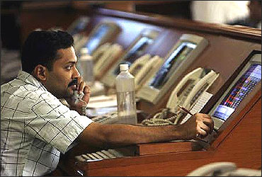 A stock brokers engages in trading at a firm in Mumbai.
