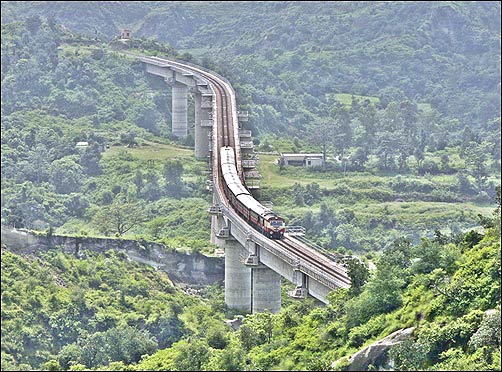 A passenger train coming from Jammu moves over a bridge on the outskirts of the city.