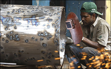 A worker uses a welding machine at a metal workshop in Mumbai.