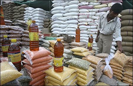 A vendor arranges packets of pulses at a wholesale market.