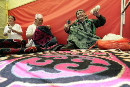 Women spin yarn at a presentation of traditional handicraft in Osh.