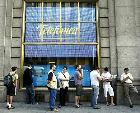 People wait in line to purchase the new iPhone 3GS on the first day it is being sold in Spain at a Telefonica store in Madrid.