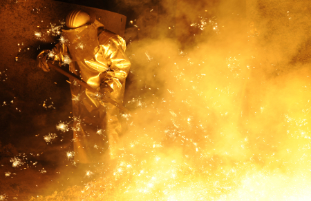 A steel-worker is pictured at a furnace at a plant.