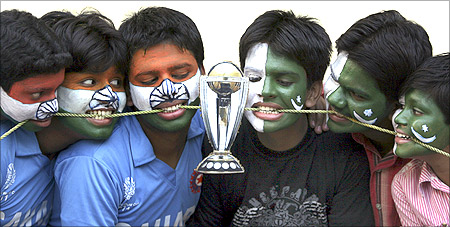 Cricket fans with their faces painted with the Indian and Pakistani national flags pose as they engage in a tug-of-war for a replica of the Cricket World Cup trophy in Hyderabad.