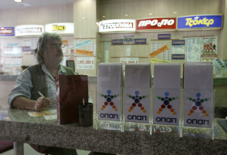 A man sits inside a lottery store in Athens.