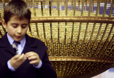 A schoolboy reads the number on a lottery ball in Madrid.