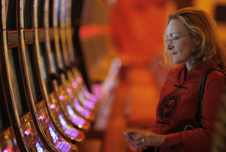 A woman looks at slots machines inside the Resorts World Sentosa casino on Singapore's Sentosa Island.