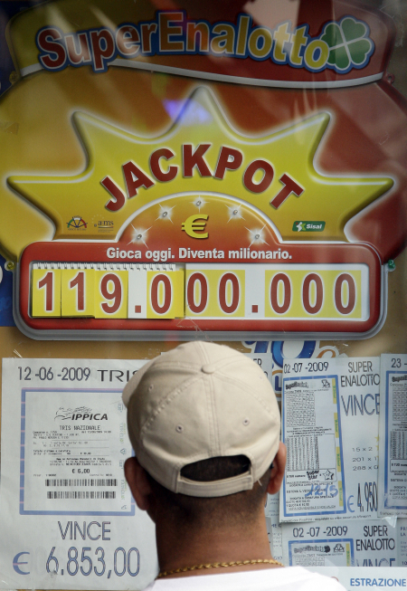 A man looks at the an advertisement for the state lottery in the window of a betting shop in Milan.
