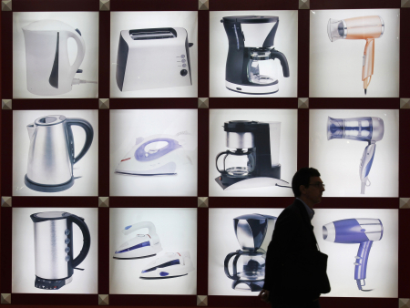 A visitor walks past photos of home electric appliances at the Canton Fair in Guangzhou, China.