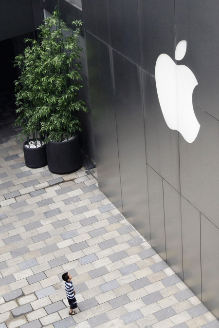 A child looks at the Apple logo outside the company's flagship store in Beijing's Sanlitun Area.