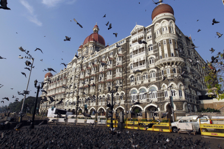 Pigeons fly in front of the Taj Mahal hotel in Mumbai.