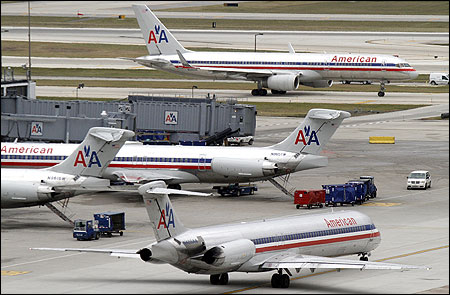 American Airlines planes sit at their gates.