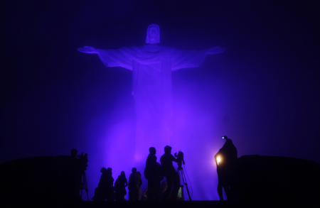 People gather at the statue of Christ the Redeemer, lit by a blue light, on the eve of World Autism Day to commemorate the annual event in Rio de Janeiro.