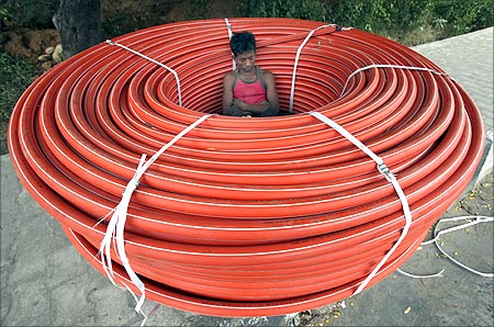 A labourer sleeps in a roll of underground cables at a construction site in Jammu.