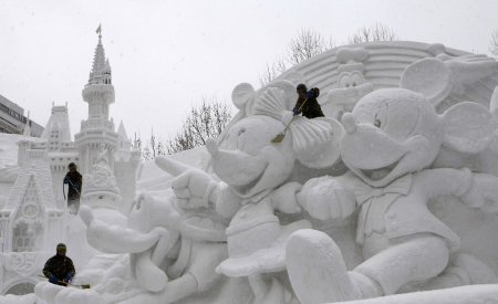 Japanese soldiers work on a snow sculpture celebrating the 25th anniversary of the Tokyo Disney Resort at the snow festival in Sapporo, Japan.