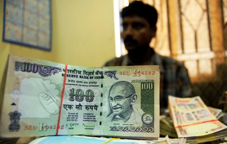 An employee arranges Indian currency notes at a cash counter inside a bank in Agartala.