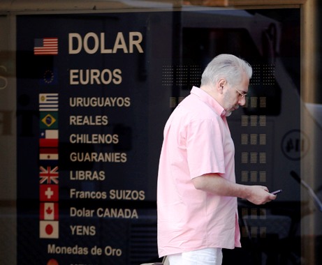 A man walks past a foreign exchange house in the financial district of Buenos Aires.