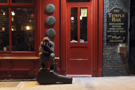 A musician sits on a bench outside a pub in Temple Bar, Dublin.