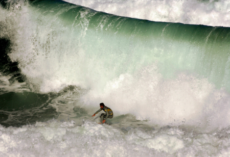 A surfer looks back at a huge wave as he rides it at Sydney's Dee Why Beach.