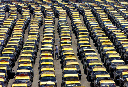 A driver walks amid rows of taxis in Mumbai.