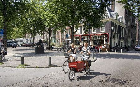 Two women ride their bicycles on the Lindengracht in Amsterdam.
