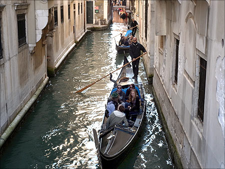 Gondolas make their way in a channel in downtown Venice.