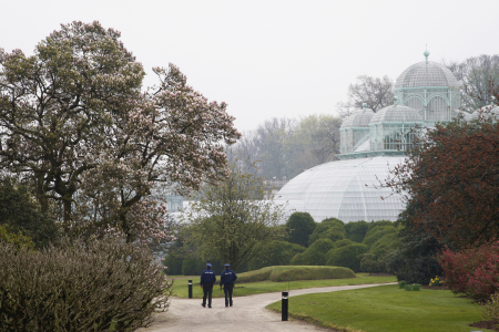 Police officers walk past greenhouses on the grounds of the Belgian royal family's residence of Laeken in Brussels.