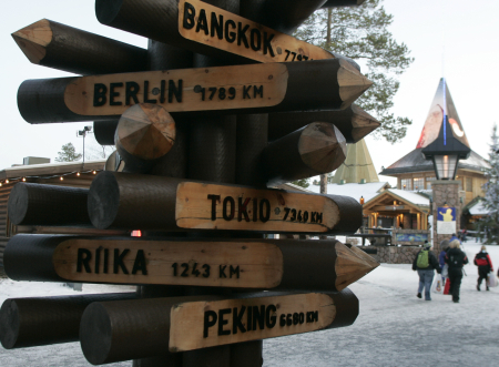 A signpost lists the distance to various cities from Santa Claus' Village at the Arctic Circle near Rovaniemi, Finland.