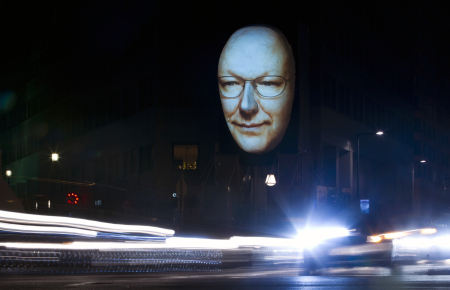 Cars drive past 'Faces of Berlin' light installation during Festival of Lights in Berlin.