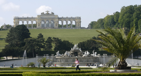 A jogger crosses the garden of Schoenbrunn castle in front of Gloriette in Vienna.