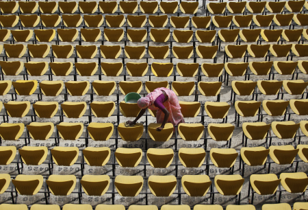 A worker cleans the seats of Vidarbha cricket association stadium in Nagpur.