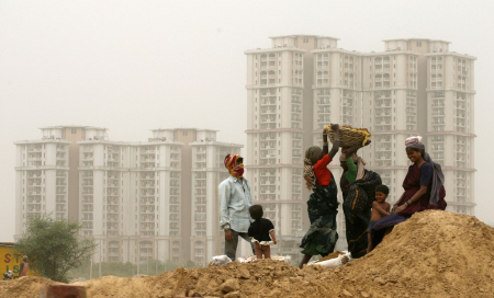 Labourers work in front of high rise residential colonies in Gurgaon.