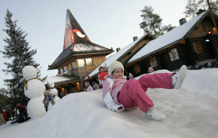 A child slides on snow in front of the Santa Claus' Office in Santa Claus' Village on the Arctic Circle near Rovaniemi, northern Finland.