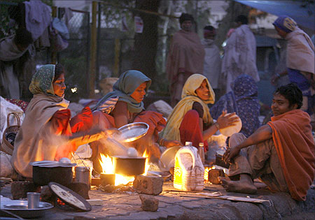 Homeless people prepare their food on a roadside near Ahemedabad.