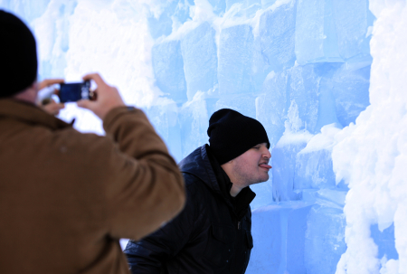 A tourist licks the outside wall of the Balea Lac Hotel of Ice in the Fagaras mountains.