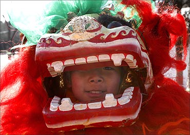 A child looks at the camera as he practises lion dance at a park in Beijing.