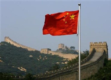 A Chinese flag flies in front of the Great Wall of China, located north of Beijing.