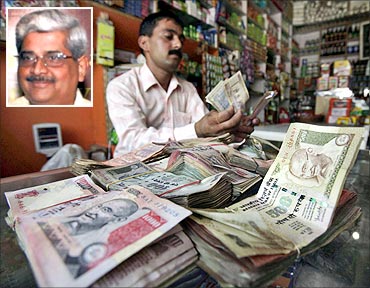 A shopkeeper counts notes inside his shop in Jammu. (Inset) R Gopalan.